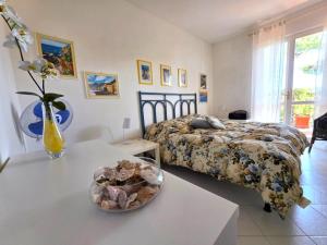 a bedroom with a bed and a table with a bowl of shells at Casa Limone by Affitti Brevi Liguria in Borgio Verezzi