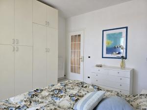 a white bedroom with a bed and a dresser at Casa Limone by Affitti Brevi Liguria in Borgio Verezzi