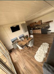 a living room with a wooden table and chairs at vaav house in Tyudov +4 photos