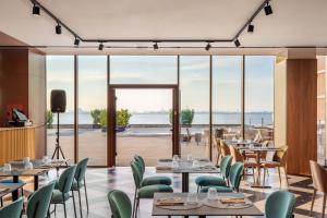 a restaurant with tables and chairs and a view of the ocean at B&B HOTEL Venezia Laguna in Venice
