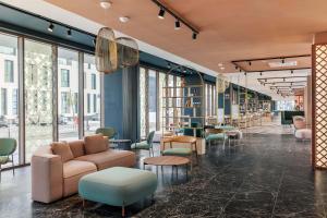 a lobby with chairs and tables and windows at B&B HOTEL Venezia Laguna in Venice