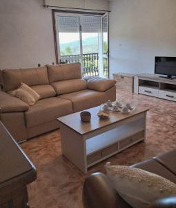a living room with a couch and a coffee table at A Morada do Cuco in Piñor