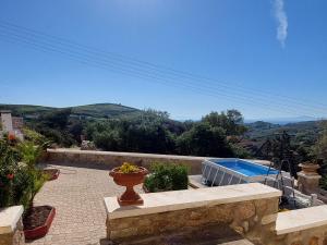 a patio with a vase on a stone bench and a swimming pool at MAFILVI Panorama in Chrousa