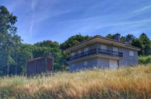 a house sitting on top of a hill in a field at A Morada do Cuco in Piñor