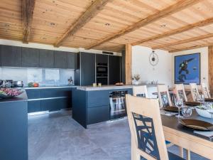 a kitchen with blue cabinets and a wooden ceiling at Chalet Familial Le Whymper 5 étoiles SPA Sauna Chatel in Châtel +35 photos