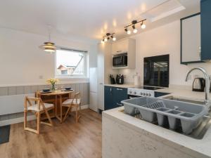 a kitchen with blue cabinets and a table and a sink at Alt na Voir in Tomintoul +16 photos