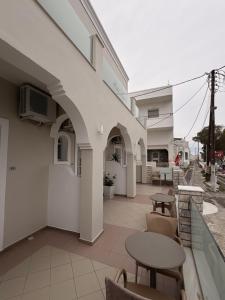 a building with a patio with tables and chairs at Rooms By Lignou in Fira