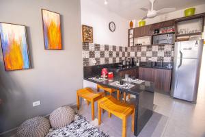 a kitchen with a table and chairs and a refrigerator at Apto Novo Duplex em Juqhey in Juquei
