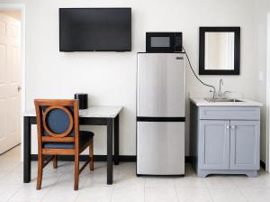 a kitchen with a refrigerator and a table and a sink at Beachside Resort in Wildwood