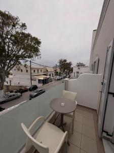a balcony with a table and chairs and a street at Rooms By Lignou in Fira +12 photos