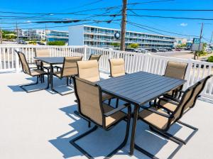 a black table and chairs on a balcony with a building at Beachside Resort in Wildwood