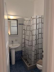 a bathroom with a sink and a shower curtain at Rooms By Lignou in Fira
