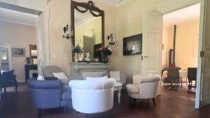 a living room with white chairs and a mirror at Domaine de ferrabouc in Mas-Saintes-Puelles +16 photos