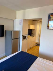 a room with a kitchen with a refrigerator and a bed at Orbi in Batumi 24 in Angisa