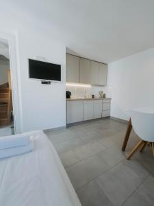 a white living room with a tv on the wall at Hiša Liza in Kobarid
