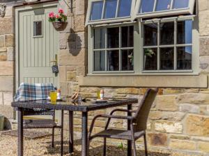 a table and chairs in front of a building at 1 Bed in Hexham oc-82472 in Hexham
