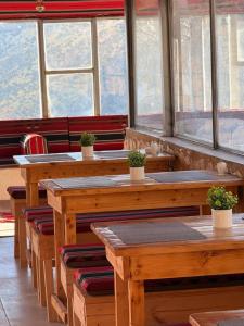 a restaurant with wooden tables and chairs and windows at DANA First View Hotel in Dana