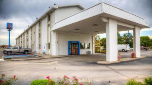 a large white building with a blue door in a parking lot at Motel 6-Council Bluffs, IA - Omaha East in Council Bluffs