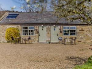 a stone cottage with tables and chairs in front of it at 1 Bed in Hexham oc-82472 in Hexham