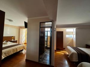 a hotel room with two beds and a mirror at Asian House in Uyuni