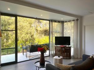 a living room with a couch and a large glass window at Villa Toscane in Meyreuil