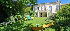a yard with chairs and tables and a building at Villa Aigarden in Avignon
