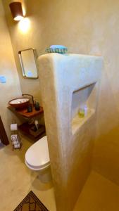 a bathroom with a white toilet in a room at Casa Pequi in Alexânia