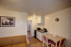 a kitchen and a living room with a table and a couch at Motel 6-Council Bluffs, IA - Omaha East in Council Bluffs