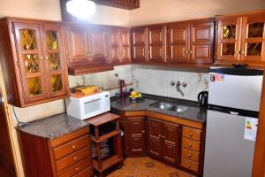 a kitchen with wooden cabinets and a white refrigerator at Residencial Garcia in Embalse