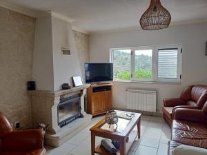 a living room with a fireplace and a tv at Casa da Fraga in Alfândega da Fé