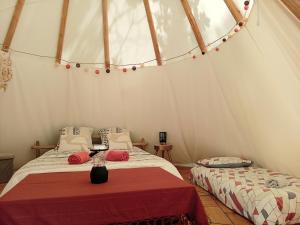 a bedroom with two beds in a tent at Le tipi à Marie, déconnectez- vous !!! in Cambounès