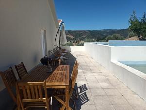 a patio with a wooden table and chairs on a balcony at Casa da Fraga in Alfândega da Fé