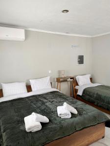 two white towels on a bed in a room at Villa Athina C in Serres