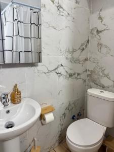 a bathroom with a white toilet and a sink at Villa Athina C in Serres