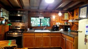 a kitchen with wooden cabinets and a sink and a stove at Log Cabin in Helen