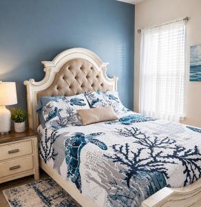 a bedroom with a bed with a blue wall at Windmark-Beach Therapy in Port Saint Joe