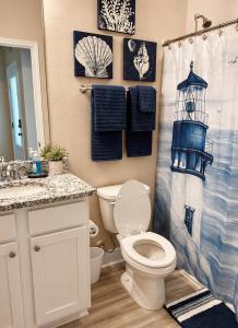 a bathroom with a toilet and a shower curtain at Windmark-Beach Therapy in Port Saint Joe +12 photos