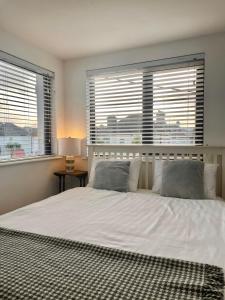 a bedroom with a large white bed with two windows at 1997 Stays Galway in Galway