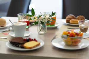 un tavolo con piatti di cibo e una tazza di caffè di Hotel Jumbo a Rimini