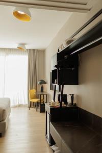 a room with a bed and a living room with a table at Grand Brizo Bel Air in Buenos Aires