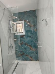a bathroom with a glass shower with a picture on the wall at Manganas Studios in Paleokastritsa +26 photos