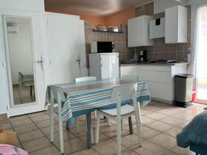 a kitchen with a table and chairs and a refrigerator at Studio 170m Plage de Sable, Clim & Parking in Le Barcarès