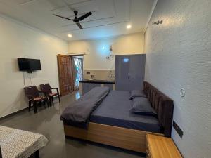 a bedroom with a bed with a ceiling fan at Singh Kainchi Dham Villa in Bhowāli