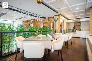 a restaurant with white chairs and tables and a balcony at Ocean Delight Boutique Hotel 海悦精品酒店 in Sihanoukville