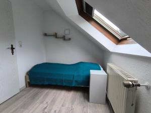a bedroom with a blue bed in a attic at Ferienwohnung am Riedrain in Eichenzell