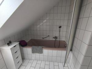 a bathroom with a bath tub in a attic at Ferienwohnung am Riedrain in Eichenzell +10 photos