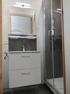 a bathroom with a sink and a shower at La Bourgandie in Englesqueville-la-Percée