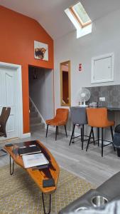 a living room with orange walls and a table at Magical 3-Bed Stone Built Cottage - Sleeps 6 in Ballynahinch