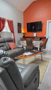a living room with a couch and a tv at Magical 3-Bed Stone Built Cottage - Sleeps 6 in Ballynahinch +11 photos