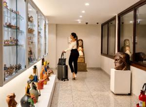 a woman walking through a museum with a suitcase at Kastel Manibu Recife - Boa Viagem in Recife